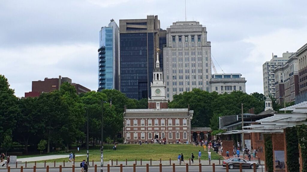 Vista amplia del Independence National Historical Park con senderos verdes y árboles que guían la mirada hacia el Independence Hall al fondo