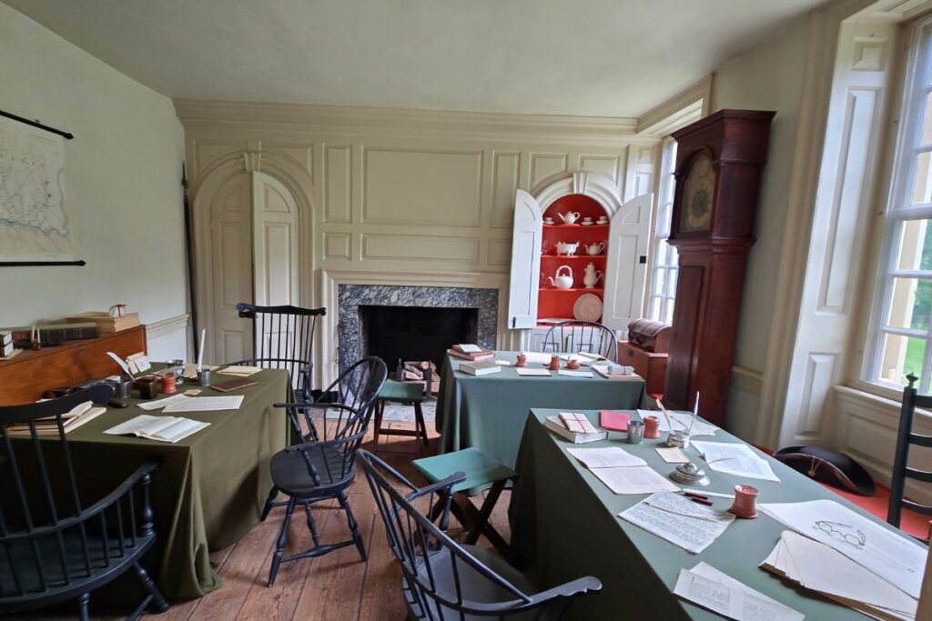 Interior de la casa de Washington. Mesas con papeles y sillas de la epoca.