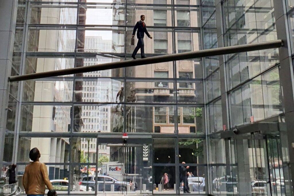 Esculturas de personas en tamaño real en vigas en el Comcast Center