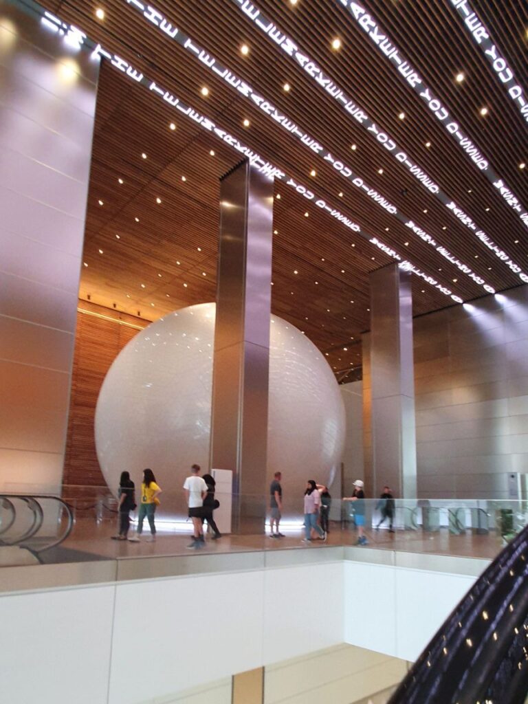 Esfera de comcast al fondo desde las escaleras electricas.